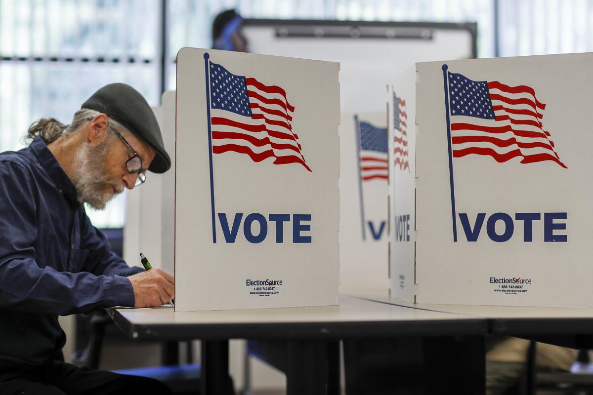 A man marks his ballot at a voting booth