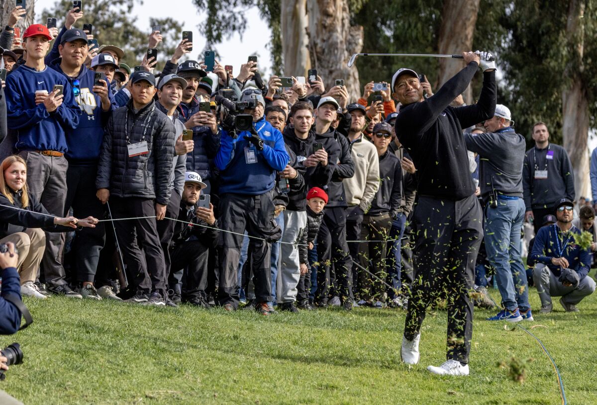 Tiger Woods hits out of the rough on the 13th hole during the second round.
