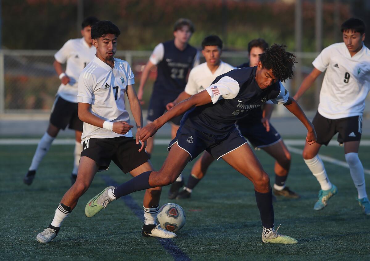 Newport Harbor's Olivier Renard tries to win a ball back from Oxnard Pacifica's Michael Sauceda (7) on Tuesday.