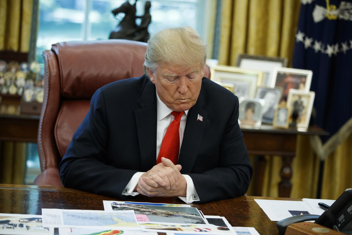 President Donald Trump looks at his notes during a briefing on Hurricane Dorian in the Oval Office of the White House, Wednesday, Sept. 4, 2019, in Washington. (AP Photo/Evan Vucci)