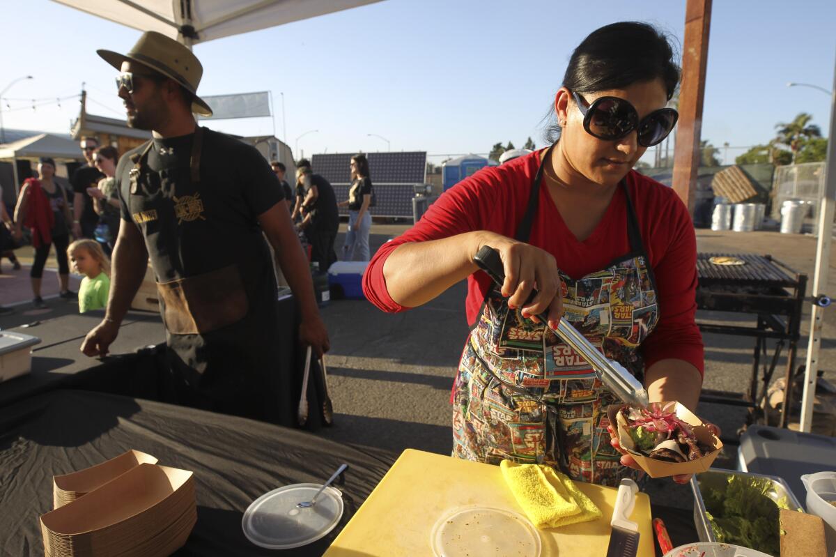Claudia Toscano makes a taco during the City Heights Street Food Festival in 2019. 