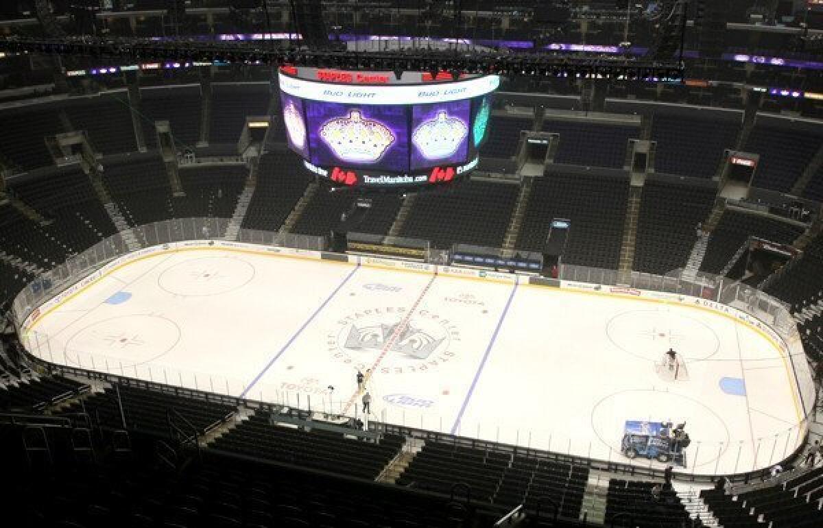 A Staples Center crew prepare the ice rink, which Blues Coach Ken Hitchcock said is "way smaller" than it should be.