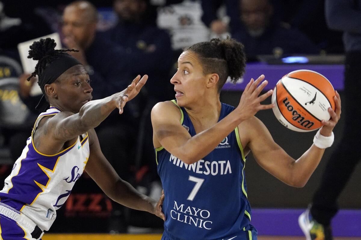 Minnesota Lynx guard Layshia Clarendon, right, tries to pass while under pressure from Los Angeles Sparks guard Erica Wheeler during the second half of a WNBA basketball game Sunday, July 11, 2021, in Los Angeles. The Lynx won 86-61. (AP Photo/Mark J. Terrill)