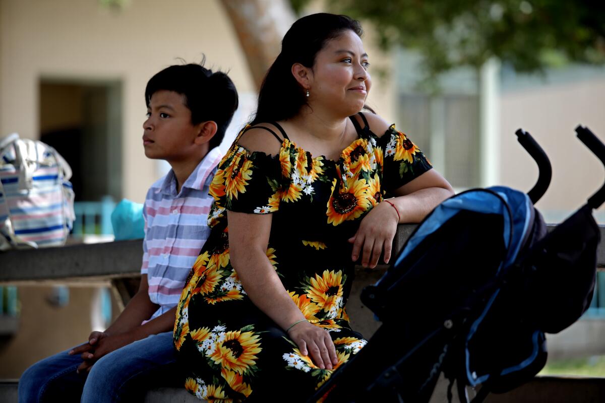 Lucrecia Puac Hernandez sits outdoors with her son Anderson Molina, 11.