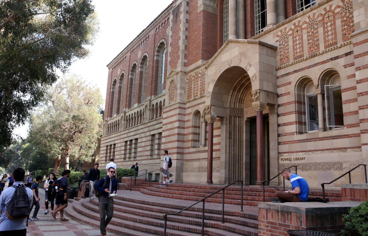 Students walk by the Powell Library at UCLA in March.