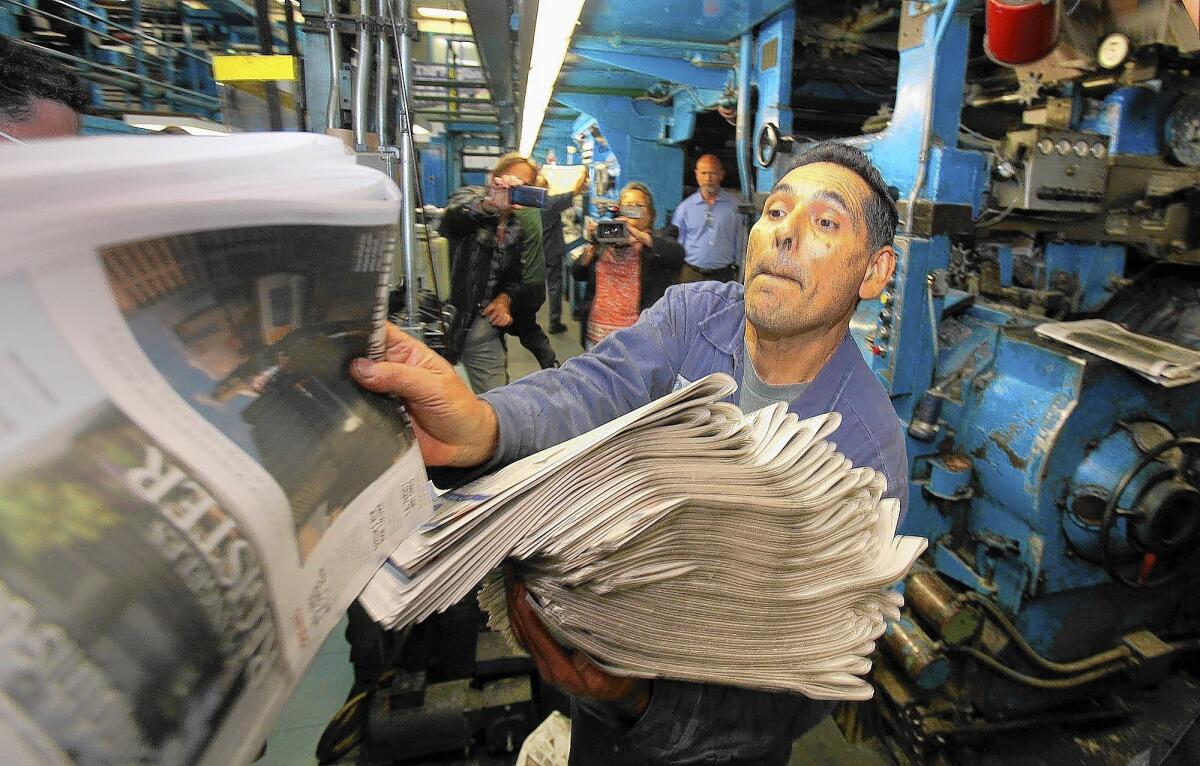 The L.A. Register, which will be sold at more than 5,500 retail outlets and vending machines, is the first new daily newspaper to launch in the city since the Los Angeles Daily News gradually turned into a daily in 1981. Above, workers check the first copies of the Register's inaugural edition at the newspaper's printing facility in Santa Ana.
