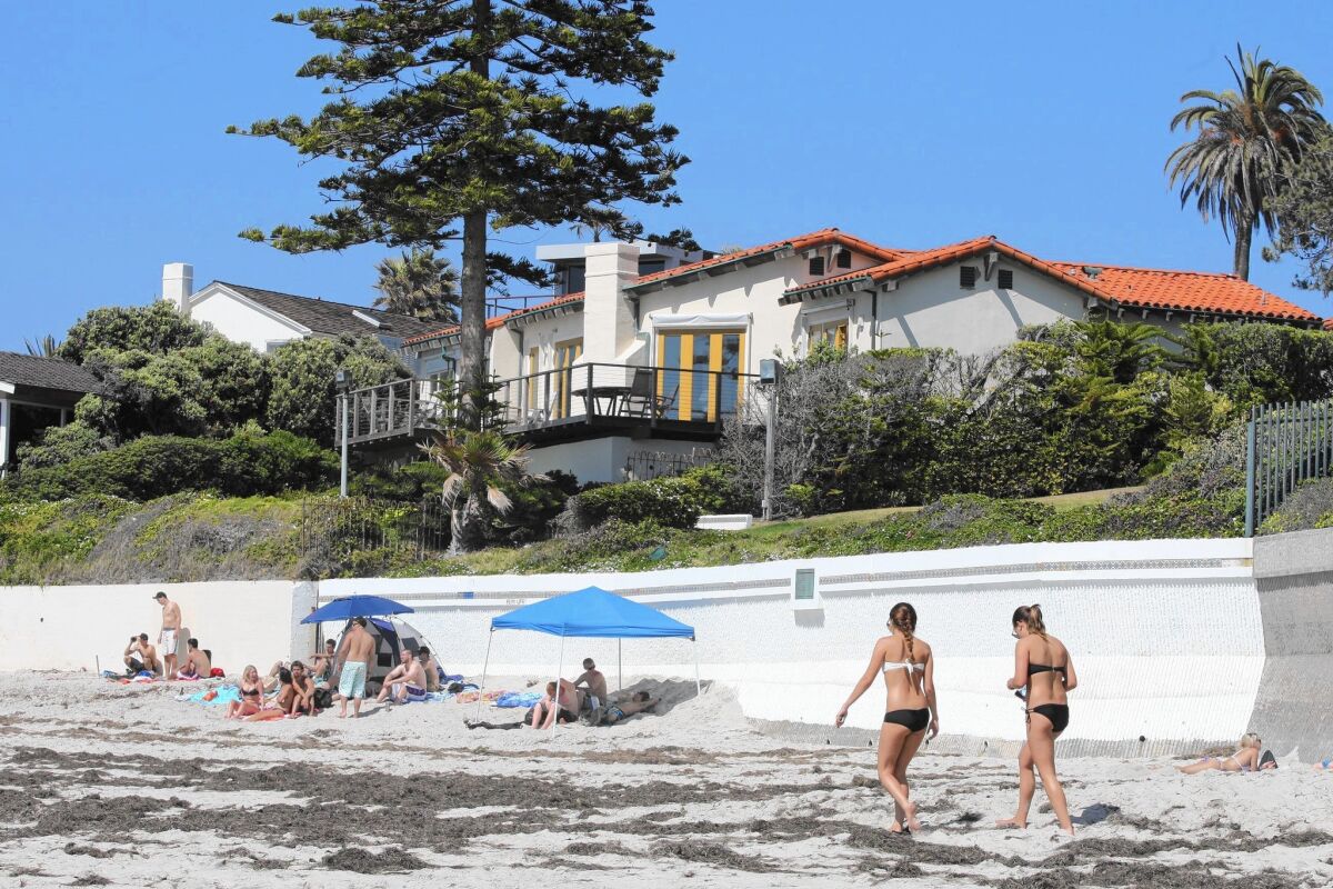 Beachgoers enjoy a sunny day in front of Mitt Romney's La Jolla home in 2012. Renovation of the $12-million residence began last spring and is expected to wrap up before the end of the year.