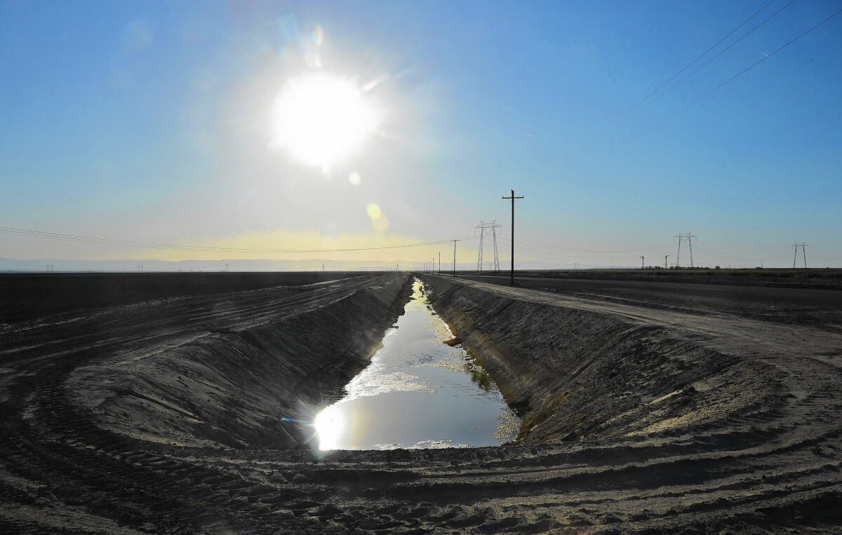 Water flows in an aqueduct amid crop fields in Kern County. The Central Valley produces more than $40 billion in crops each year, making California the biggest ag state in the U.S.