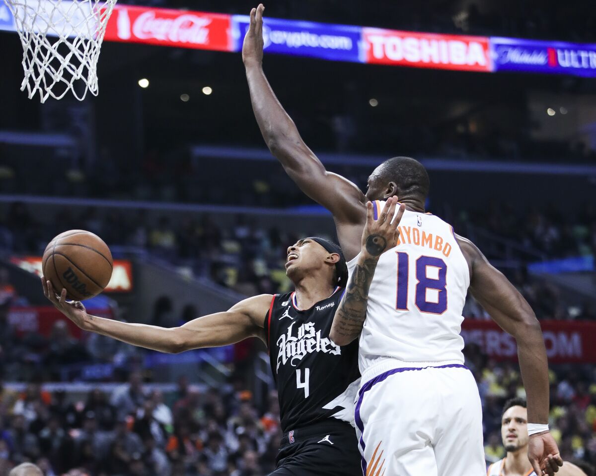 Clippers guard Brandon Boston Jr. takes a shot while being pressured by Phoenix Suns center Bismack Biyombo.