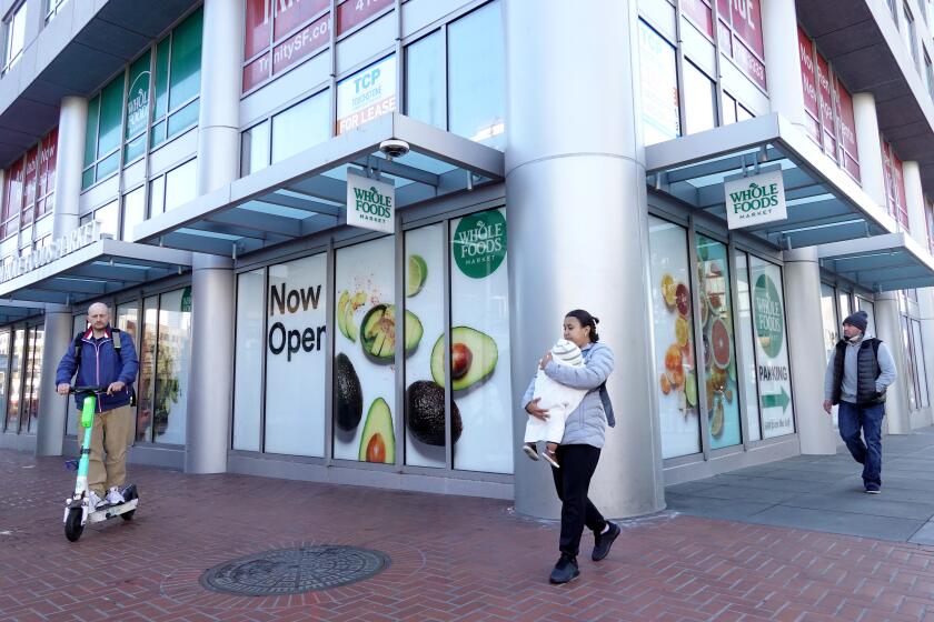SAN FRANCISCO, CALIFORNIA - APRIL 12: Residents pass by an advertisement for a Whole Foods store on April 12, 2023 in San Francisco, California. Whole Foods has temporarily closed one of its San Francisco locations due to rampant shoplifting and continued threats to workers and customers. The store opened one year ago and has struggled with deteriorating street conditions including open drug use and other crimes near the store. (Photo by Justin Sullivan/Getty Images)