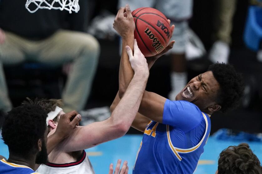 UCLA guard Jaylen Clark, right, fights for a rebound with Gonzaga forward Drew Timme, left, during the first half of a men's Final Four NCAA college basketball tournament semifinal game, Saturday, April 3, 2021, at Lucas Oil Stadium in Indianapolis. (AP Photo/Michael Conroy)