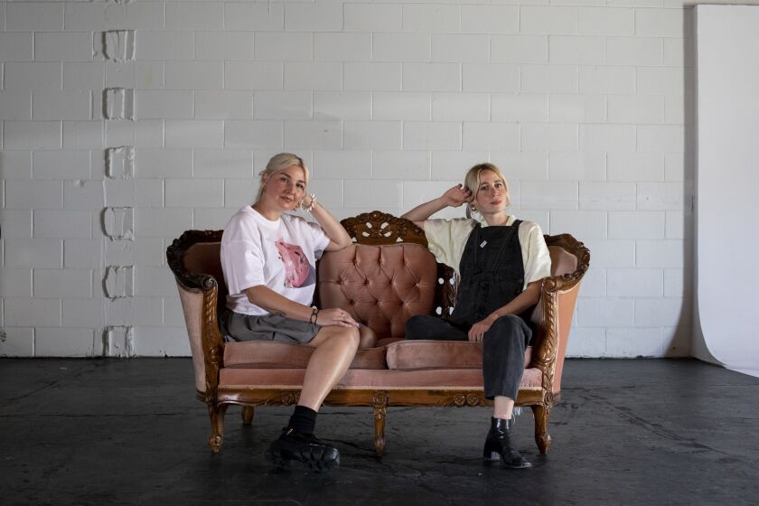 San Diego, California - April 15: Dani Higgins, 43, left, and Laurie Nasica, 32, pose for a portrait inside Department, a space known for throwing art shows and concerts on Friday, April 15, 2022 in San Diego, California. Higgins, owner, opened the space in March of 2020 and wears multiple hats as a DJ, marketing director and director for music videos and Nasica is a painter and sewist. (Ana Ramirez / The San Diego Union-Tribune)