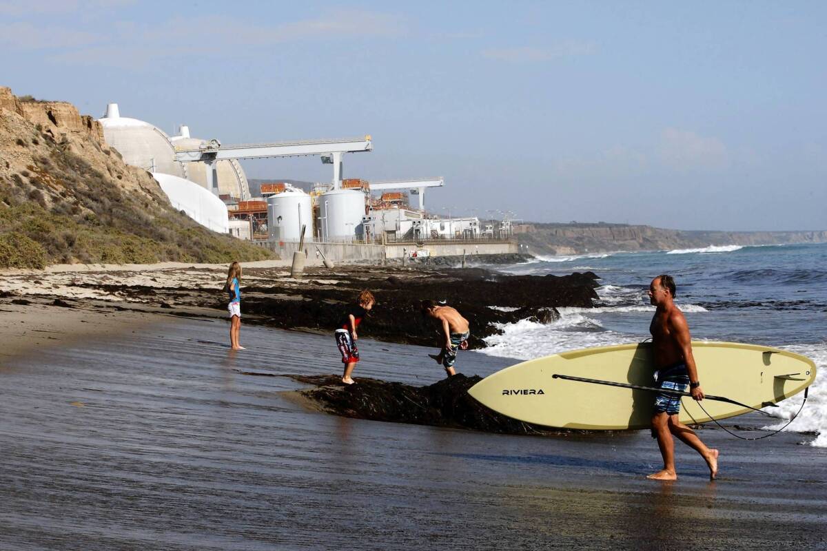 Surfers and swimmers at the seashore near the San Onofore nuclear power plant. A report on the root causes of problems at the plant shows that officials considered making design changes to its new steam generators before they were installed but rejected some fixes in part because they might require further regulatory approvals.