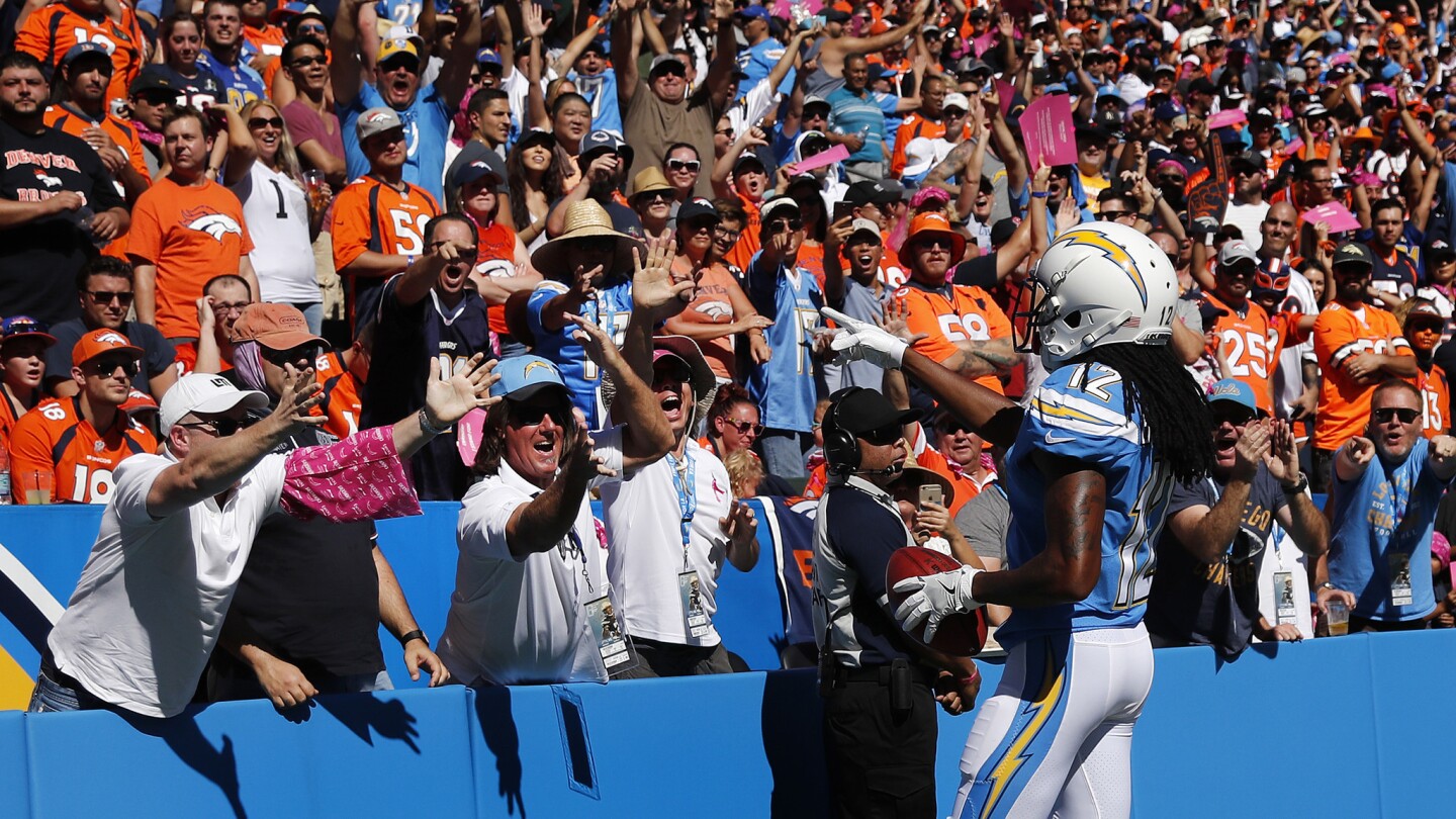 Chargers wide receiver Travis Benjamin points to cheering fans after scoring on a 65-yard punt return in the first half.