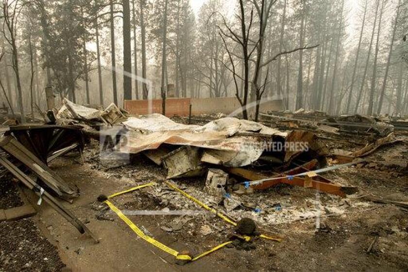 Tape marks a spot where sheriff's deputies recovered the body of a Camp fire victim in Paradise, Calif., last year.