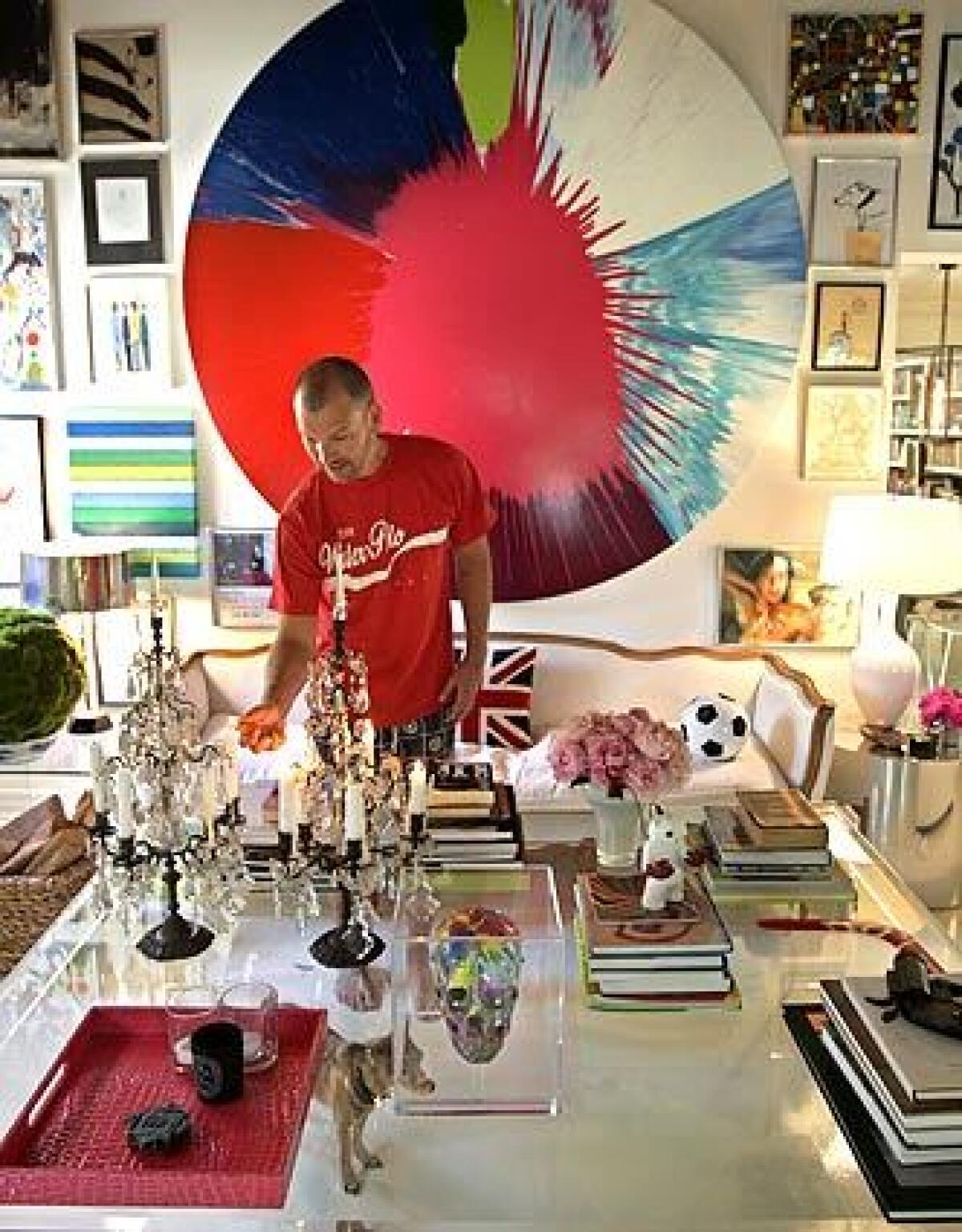 Johnson Hartig, co-designer of clothing line Libertine, lights a candelabra at the 1920s Mediterranean bungalow he renovated in Los Angeles' Hancock Park area. A huge spin-art work by Damien Hirst radiates color in the living room, dominated by an oversized Lucite table.