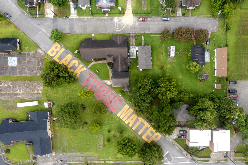 The words "Black Towns Matter" form a mural on a street, seen from above.