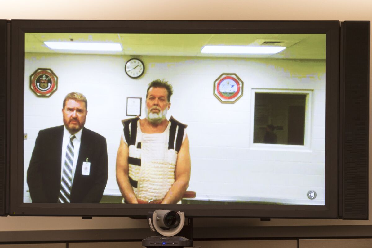 Colorado Springs Planned Parenthood shooting suspect Robert Dear, shown with public defender Dan King, appears via video hearing during his first court appearance, where he was told he will be charged with first-degree murder.