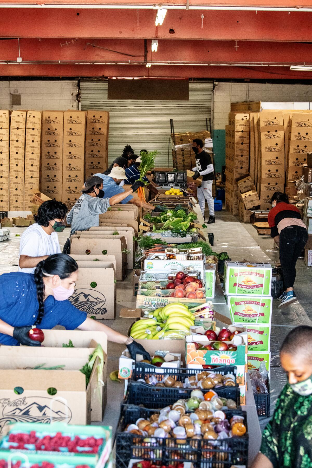 Numerous volunteers help to pack produce boxes at Summaeverythang headquarters in South L.A.