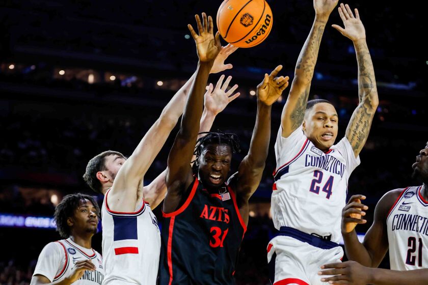 Houston, TX - April 3: San Diego State forward Nathan Mensah (31) is fouled by Connecticut guard Jordan Hawkins (24) during the first half of the national championship game of the 2023 NCAA MenOs Basketball Tournament played between the San Diego State Aztecs and the Connecticut Huskies at NRG Stadium on Monday, April 3, 2023 in Houston, TX. (K.C. Alfred / The San Diego Union-Tribune)