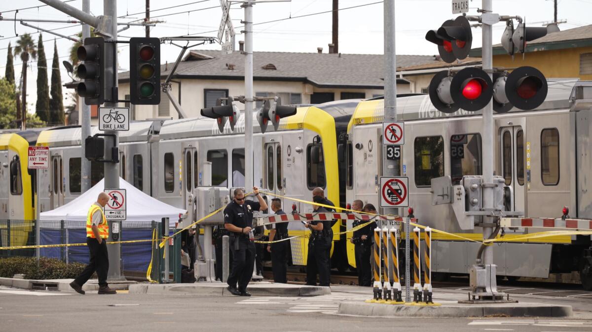 A tent covers the body of a pedestrian who was struck and killed by a Metro Expo Line train Monday.