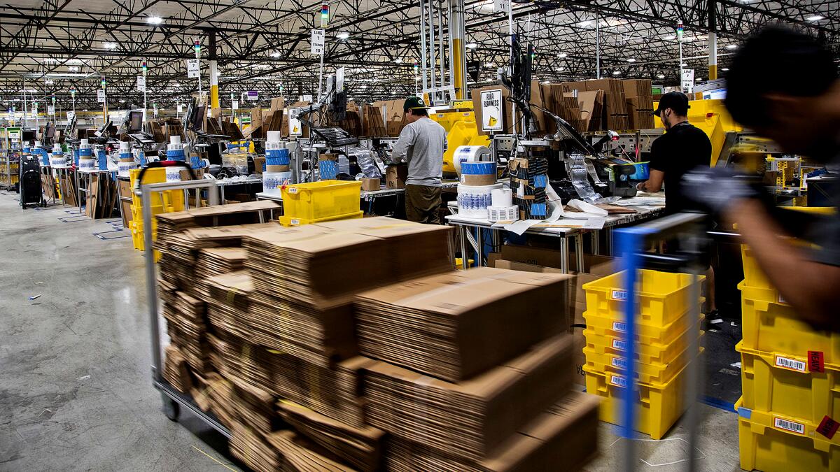 Workers pack orders at an Amazon facility.
