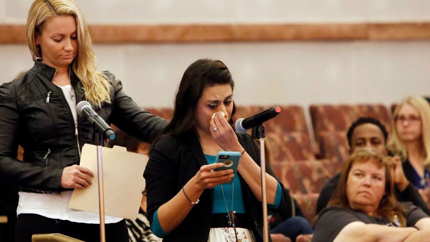 Lillian Aguirre, a survivor of the Oct. 1 mass shooting at an outdoor music festival in Las Vegas, is comforted by Laura Puglia as she speaks before the Las Vegas Victims Fund Committee on Nov. 28.
