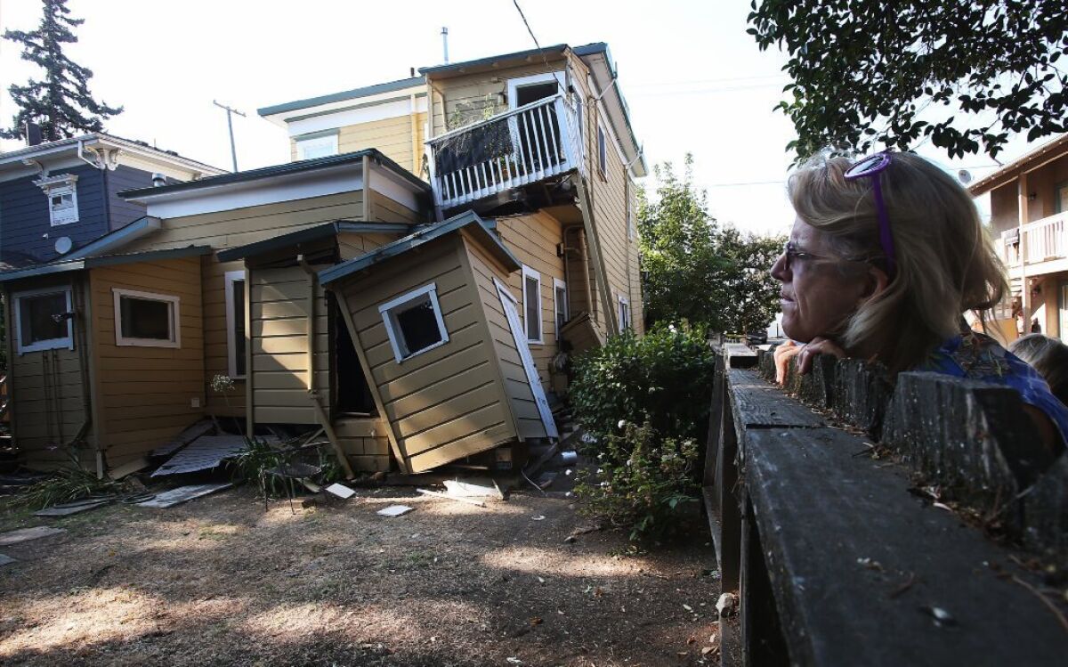 A woman eyees a red-tagged home near downtown Napa after a magnitude 6.0 earthquake in August 2014. An early alert system gave a 10-second warning before the quake hit.