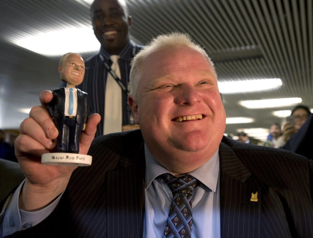 Toronto Mayor Rob Ford has shaken off the ridicule that followed his admission of smoking crack cocaine and "getting hammered." In this Nov. 12 photo, he shows off the bobblehead doll created to lampoon him, which he has been signing as souvenirs for fans.