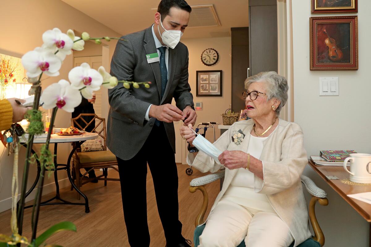 Executive Director Ben Rodny helps hand resident Joan Cox, 86.