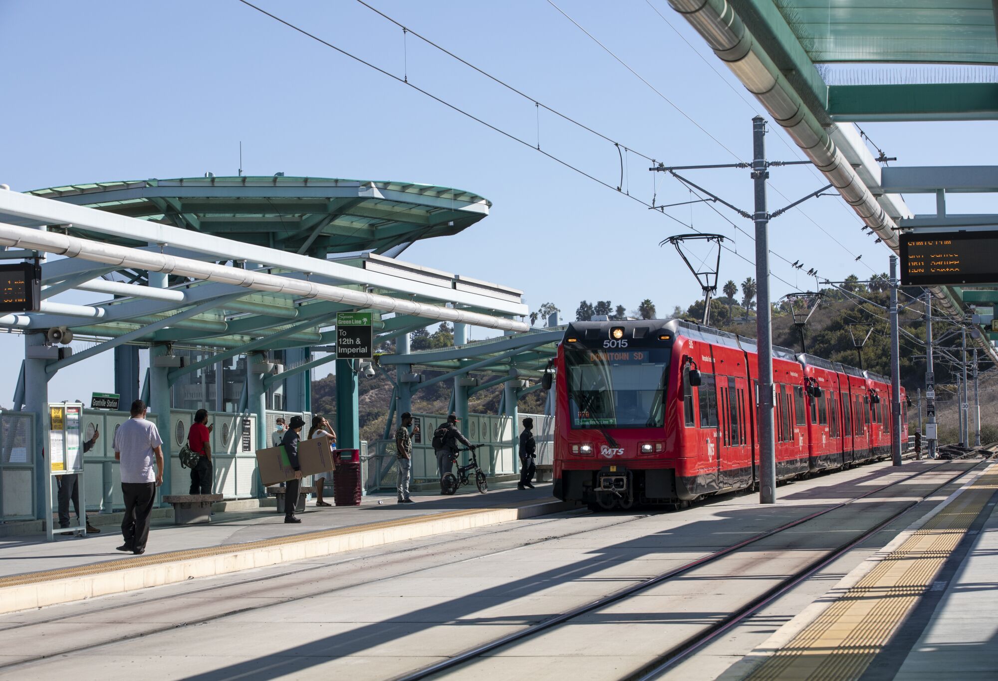 People board the San Diego Trolley's green line at the Grantville station.