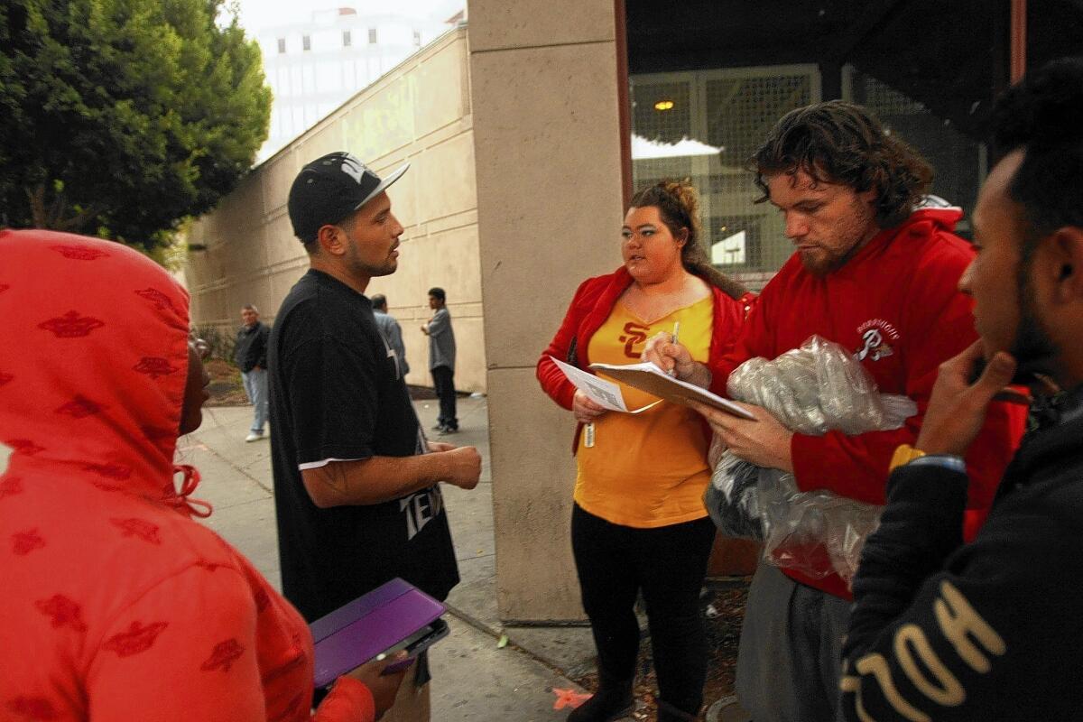 From left, activists Tiffany Usher, 22, Jose Garcia, 22, and Bryan Juarez, far right, 19, get Jason Delaney, second from right, to sign a petition to end sheriff violence shortly after Delaney was released from the Men's Central Jail in Los Angeles in late January. Delaney's sister Chadney, center, picked up her brother when he was released.