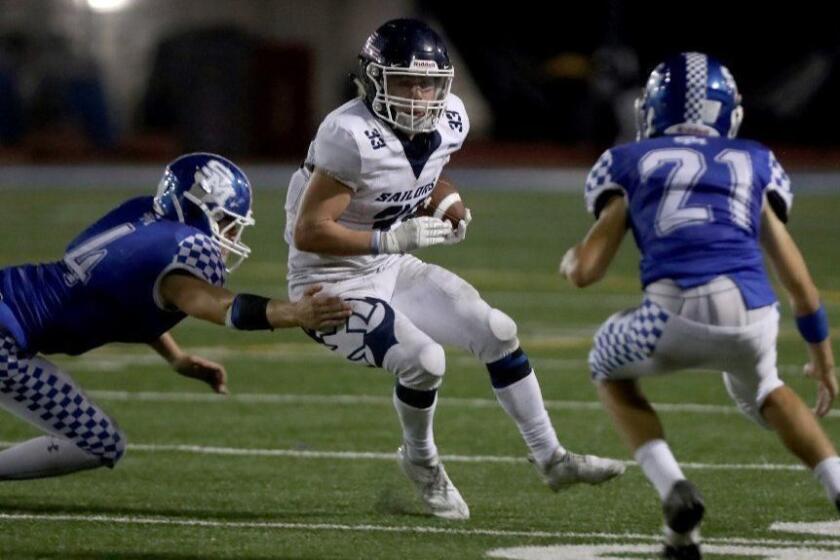Newport Harbor High School player #33 Justin Mccoy runs the ball in the second half of the first-ever non-league football game vs. San Marino High School in San Marino, on Friday, Sept. 21, 2018.