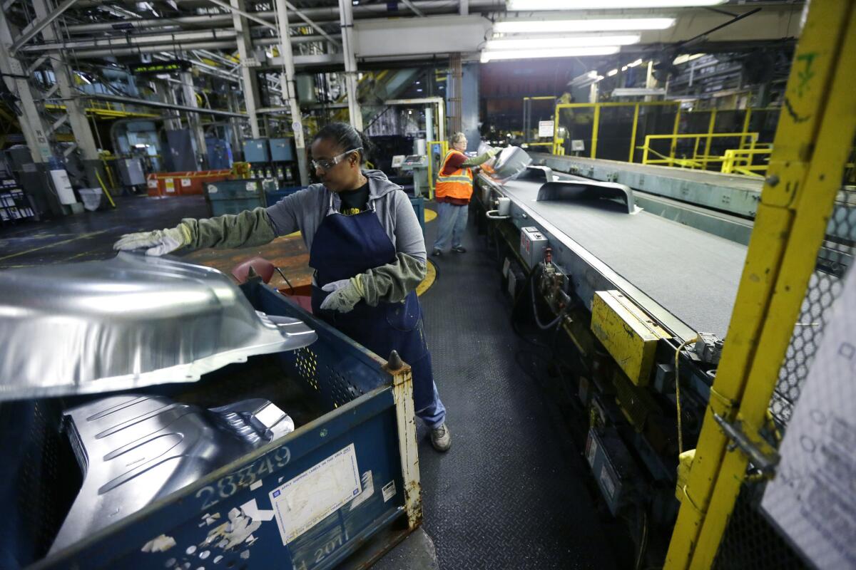 Line worker Michelle Albritton loads stamped wheel housings at the General Motors Pontiac Metal Center in Pontiac, Mich., on Thursday.