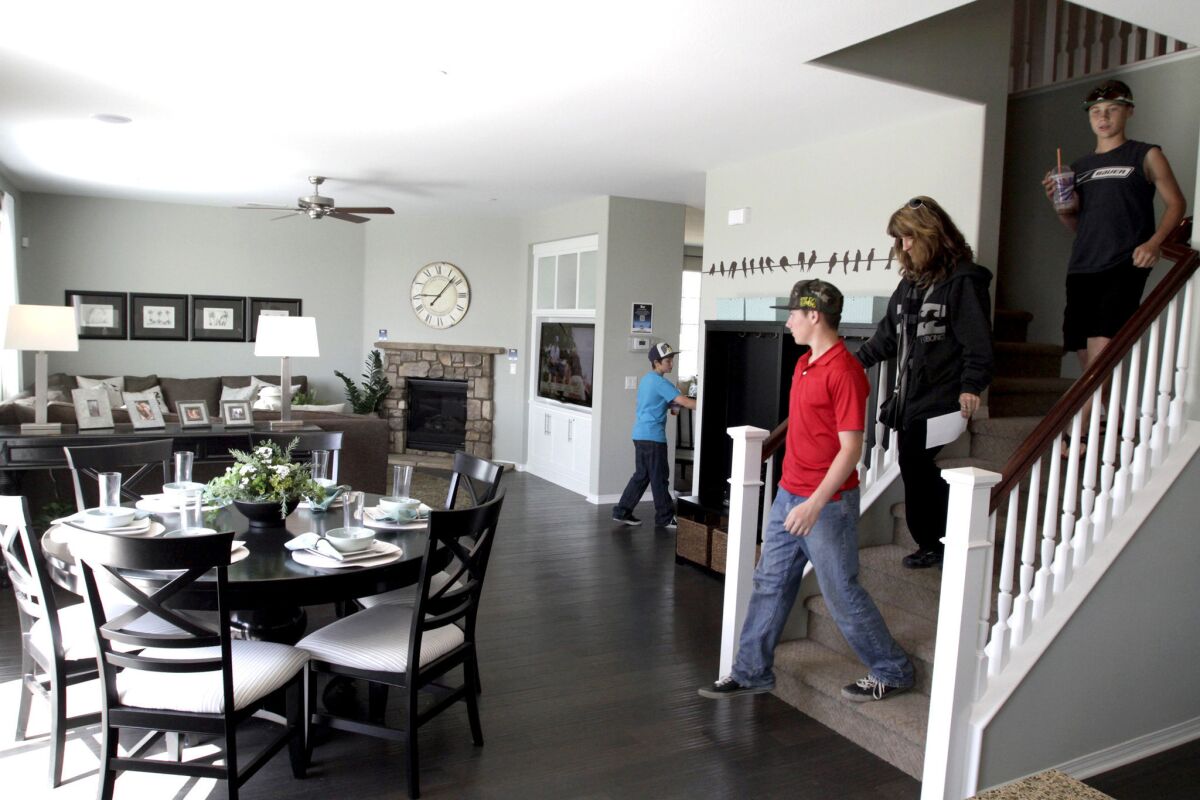 Rates for 30-year mortgages are at a 10-week low, Freddie Mac says. Above, a family tours a model home in San Bernardino.