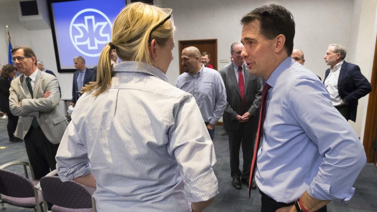 Gov. Scott Walker, right, speaks to a worker at a Kimberly-Clark plant in Neenah, Wis., on Thursday.