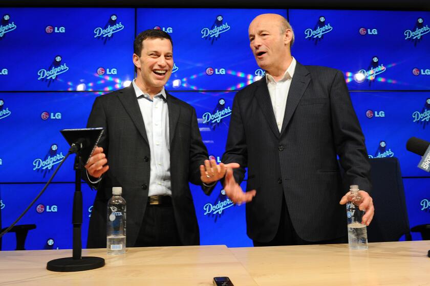 Dodgers President of Baseball Operations Andrew Friedman, left, and President and CEO Stan Kasten pose for photos during a press conference in 2014.
