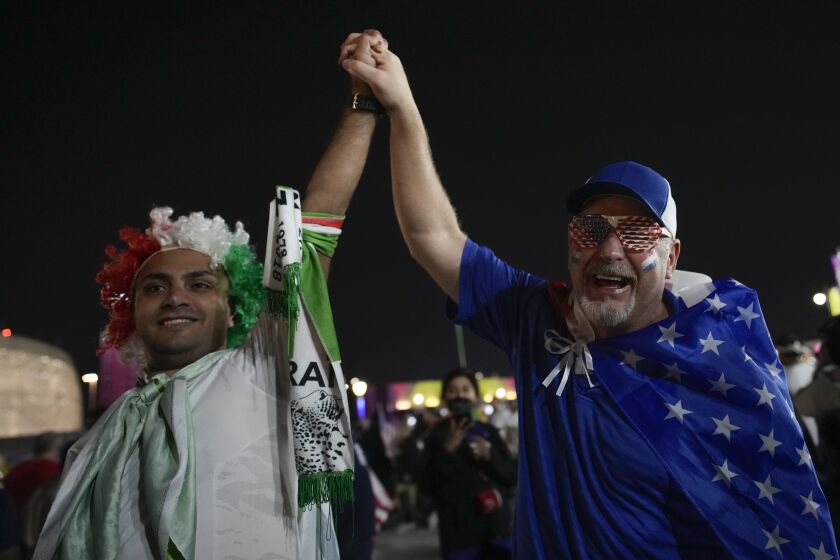 Iranian and US supporters cheer before the World Cup group B soccer match between Iran and the United States at the Al Thumama Stadium in Doha, Qatar, Tuesday, Nov. 29, 2022. (AP Photo/Christophe Ena)