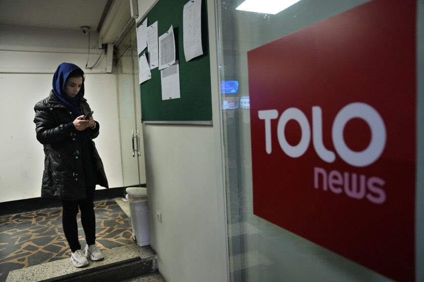 Afghan journalist Madina Morwat, checks her mobile at TOLO TV newsroom, in Kabul, Afghanistan, Tuesday, Feb. 8, 2022. A December survey jointly carried out by Reporters Without Borders and the Afghan Independent Journalist Association, reported "a total of 231 media outlets have had to close and more than 6,400 journalists have lost their jobs", since the Taliban's August arrival in the Afghan capital. (AP Photo/Hussein Malla)