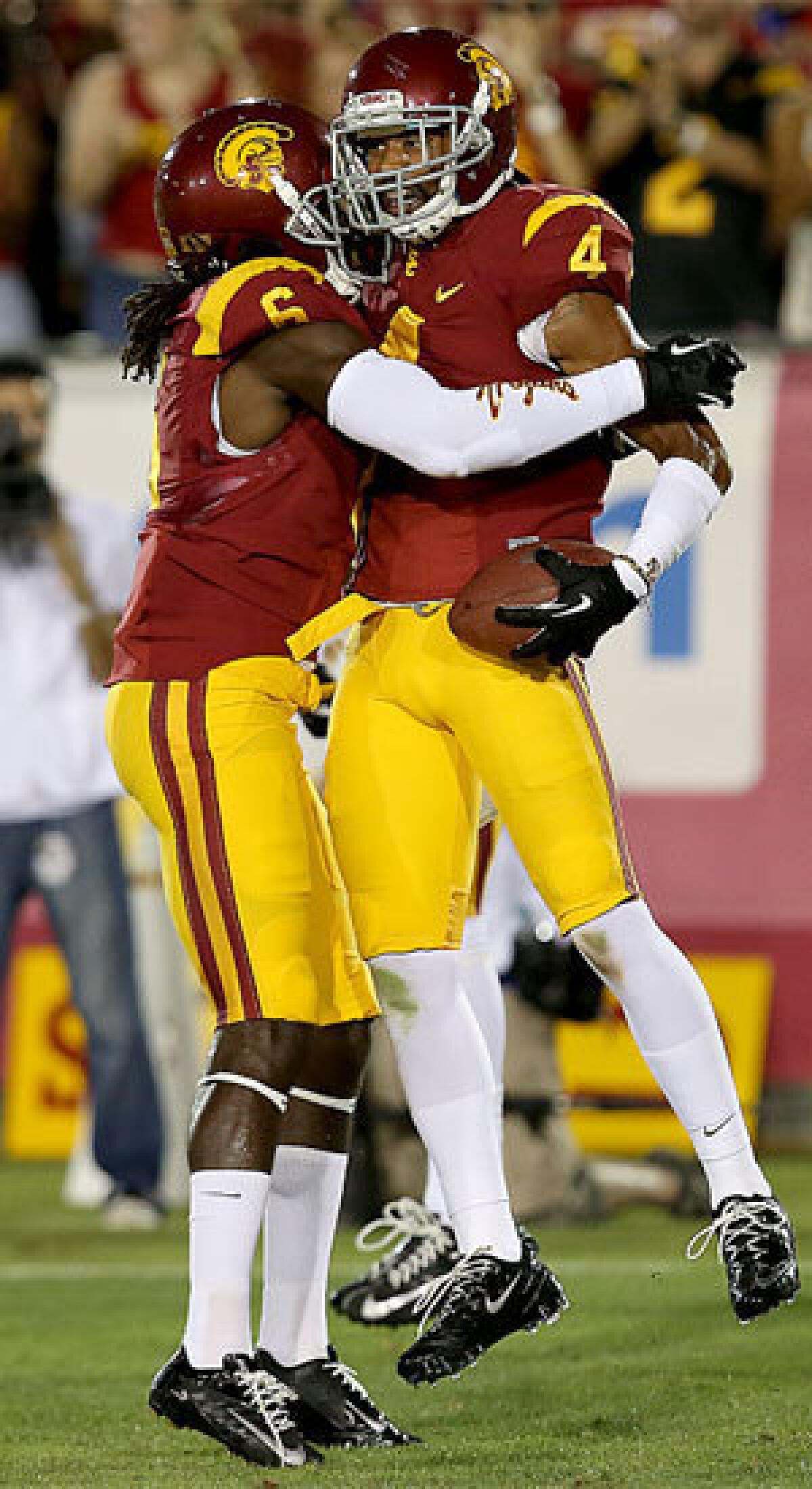 USC cornerback Torin Harris is congratulated by teammate Josh Shaw after intercepting a pass by Washington State quarternback Connor Halliday on Saturday.