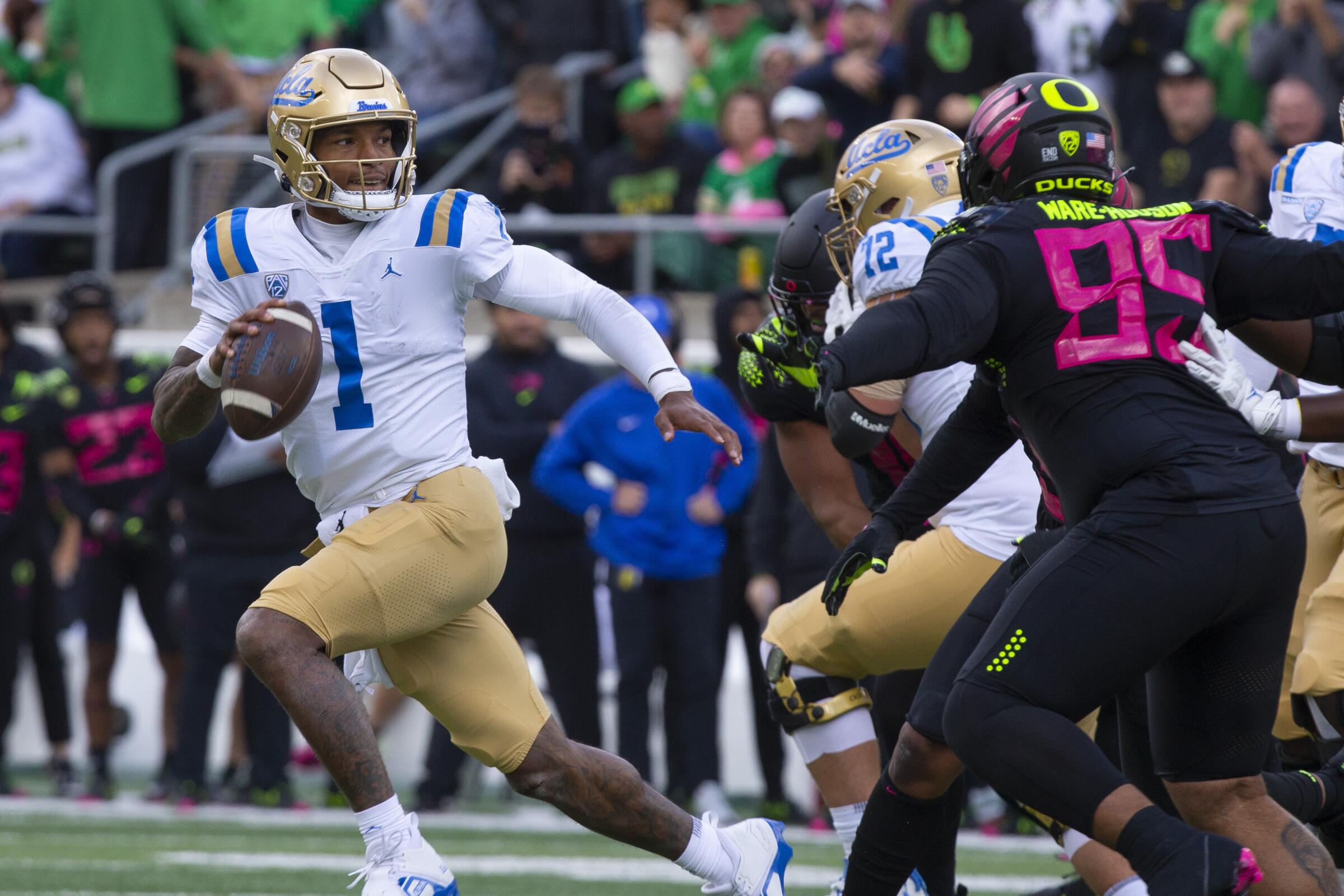 UCLA 's Dorian Thompson-Robinson runs out of the pocket under pressure from the Oregon defense.