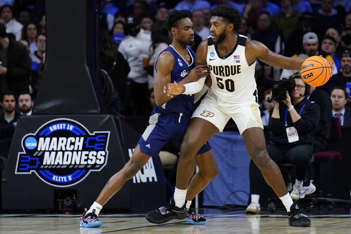 Purdue's Trevion Williams, right, tries to get past Saint Peter's KC Ndefo during the first half of a college basketball game in the Sweet 16 round of the NCAA tournament, Friday, March 25, 2022, in Philadelphia. (AP Photo/Matt Rourke)