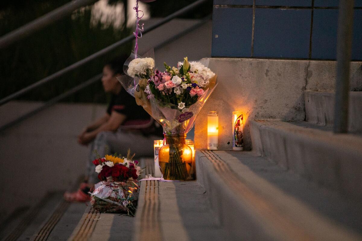 Candles and flowers sit on stairs outdoors