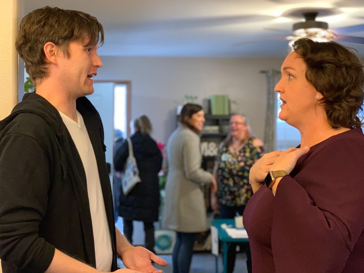 Rep. Katie Porter of Irvine speaks with voter Matthew Neppel at a campaign gathering in Cedar Rapids, Iowa, in January.