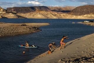 LAS VEGAS, NV -JULY 12, 2022: Children frolic on the shore lines on Boulder Beach at the drought stricken Lake Mead on July 12, 2022 in Las Vegas, Nevada. The water levels at Lake Mead are at historic lows forcing the closures of all but one marina at the lake.(Gina Ferazzi / Los Angeles Times)