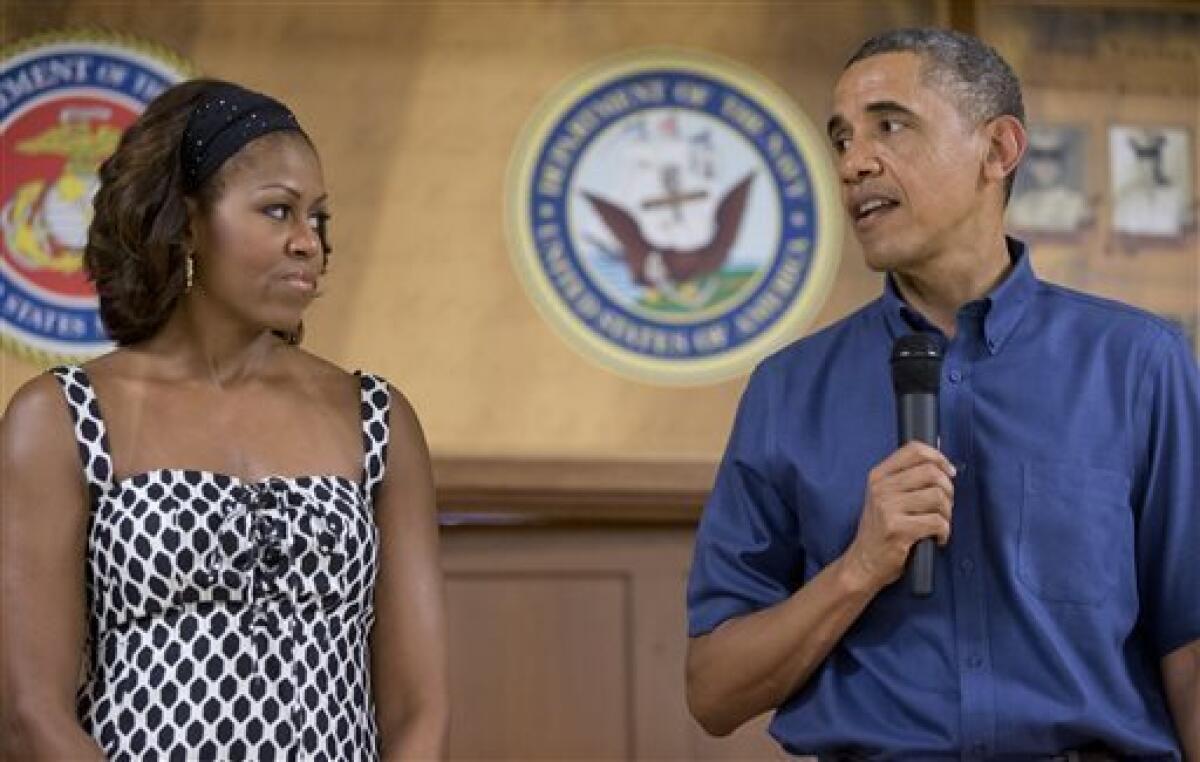 First Lady Michelle Obama and President Obama look to each other as the president speaks to members of the military and their families at Marine Corps Base Hawaii on Christmas Day.