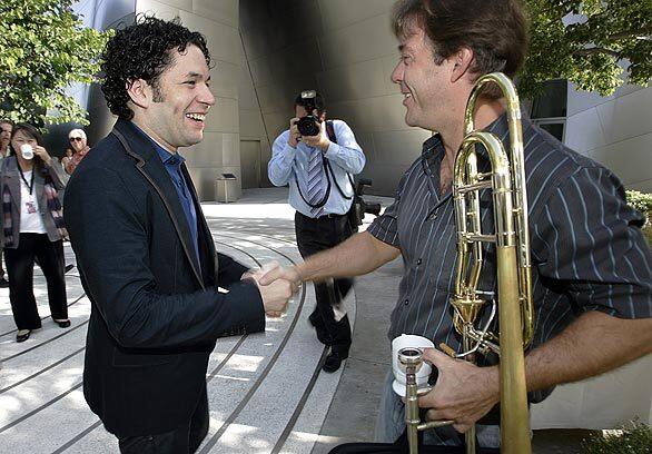 Gustavo Dudamel greets associate principal trombonist James Miller on his first day of rehearsals.