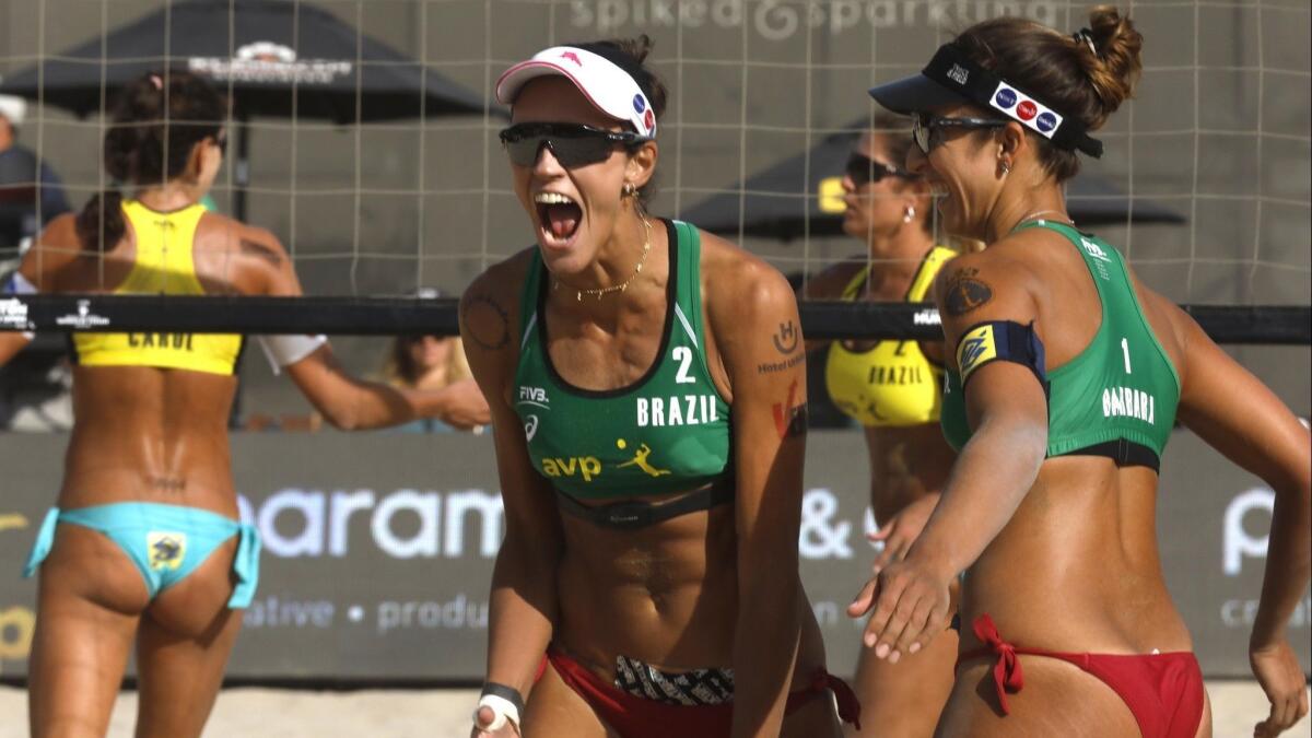 Fernanda Alves, center, and Barbara Seixas, right, of Brazil, celebrate a point during the women's final match at the FIVB Huntington Beach Open on Sunday.