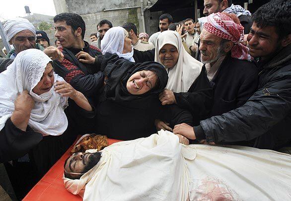 Palestinian relatives react over the body of Thabet Jenad, who according to Palestinian medical sources was killed in an Israeli army operation Sunday, during his funeral in Jebaliya in the northern Gaza Strip, Monday, March 3, 2008.