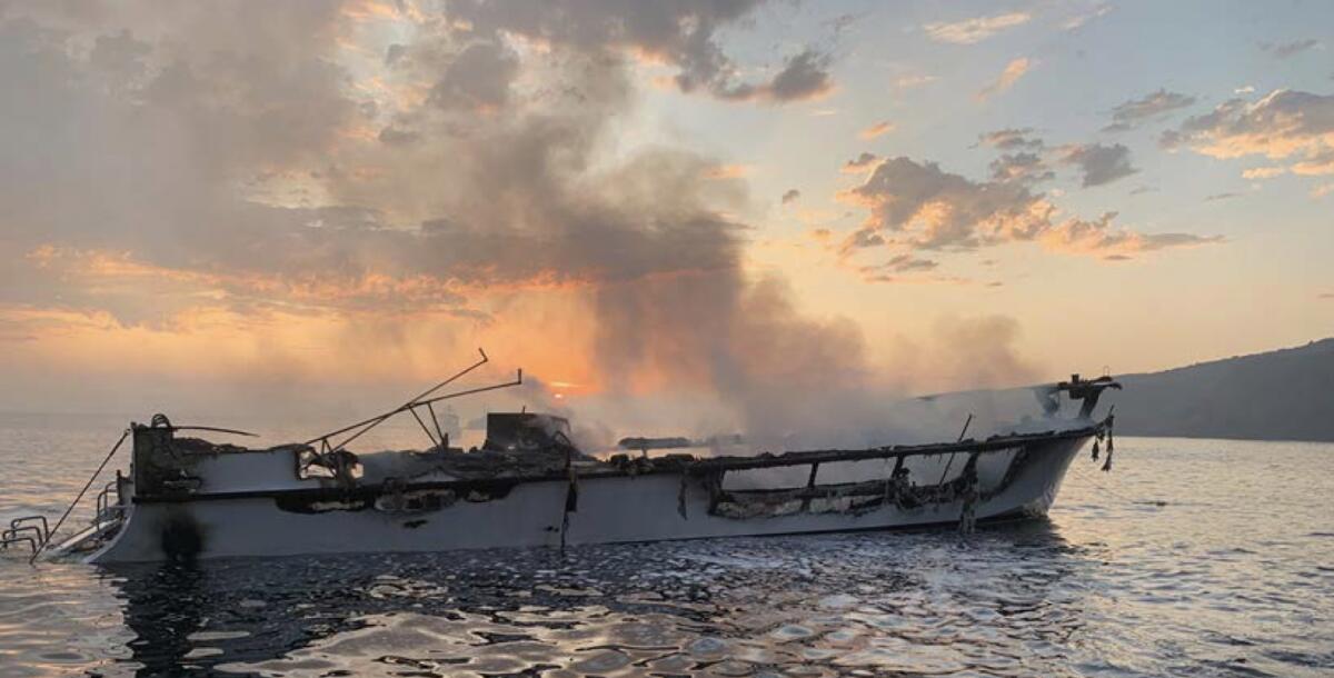 The Conception smolders at sunrise on Sept. 2, 2019, prior to sinking. 
